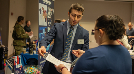 student handing resume to employer at career fair